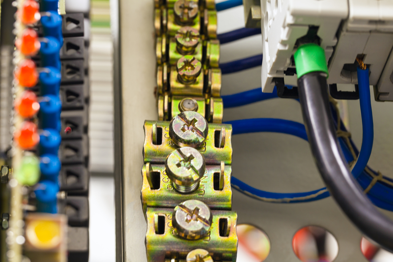 Close-up image of electrical wires is connected to cuprum clamps in power system of direct voltage with electrical circuit breakers for communication equipment. Close-up image of electrical wires is connected to cuprum clamps in power system.